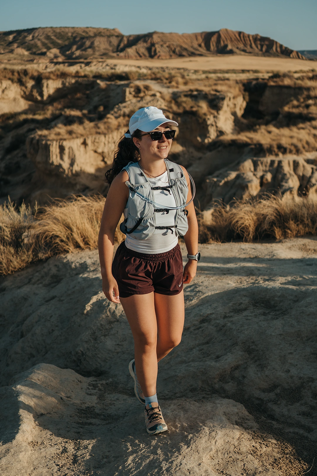 Britt hiking across a sunlit rocky landscape