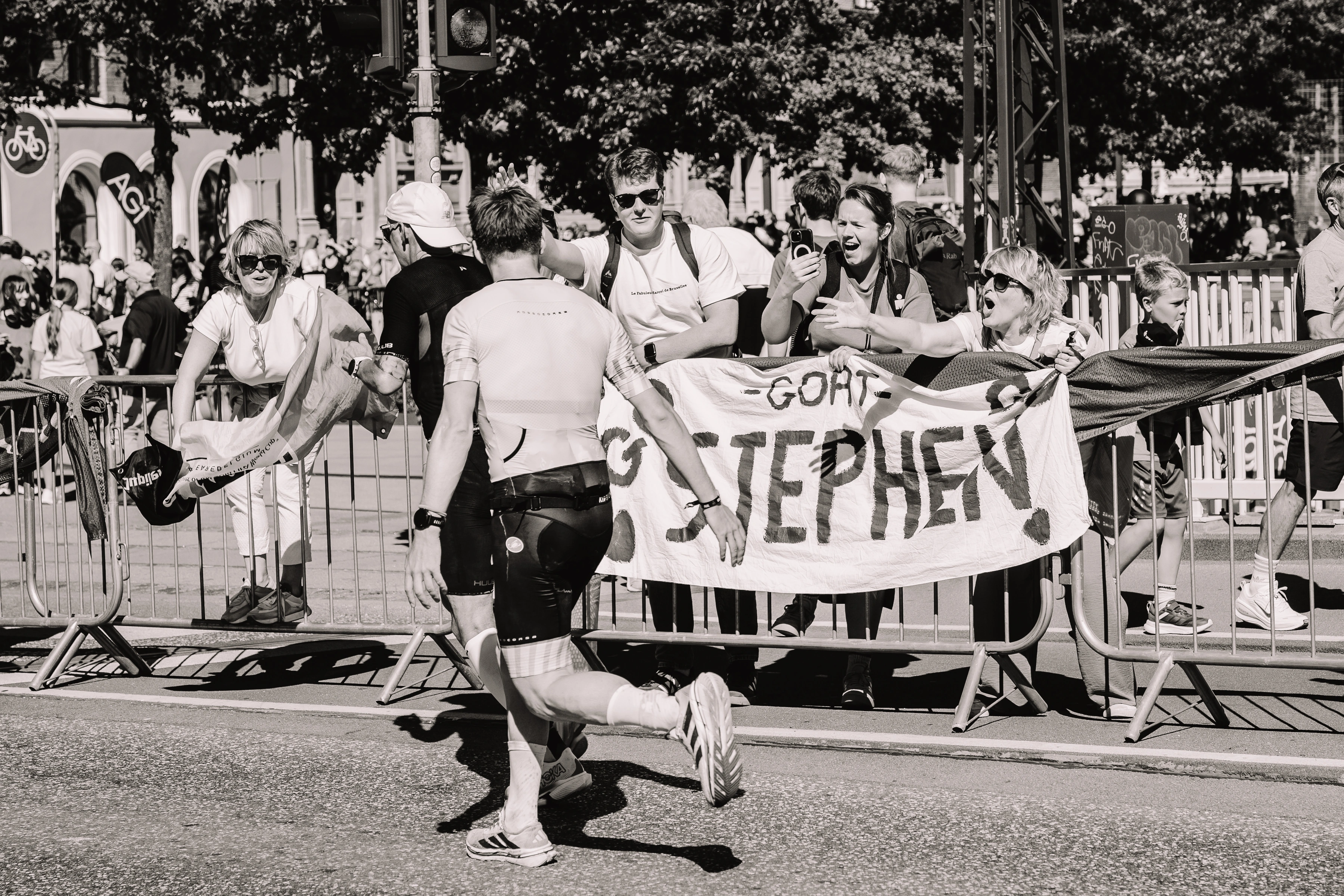 Stephen running toward supporters holding a banner with his name
