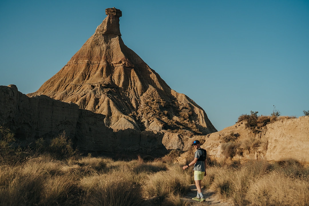 A traveler crossing an open desert landscape